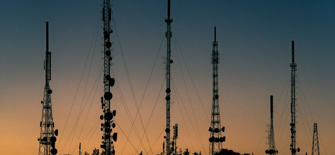 black towers during sunset cell tower antennas city
