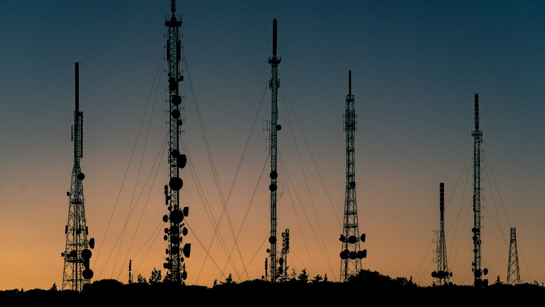 black towers during sunset cell tower antennas city