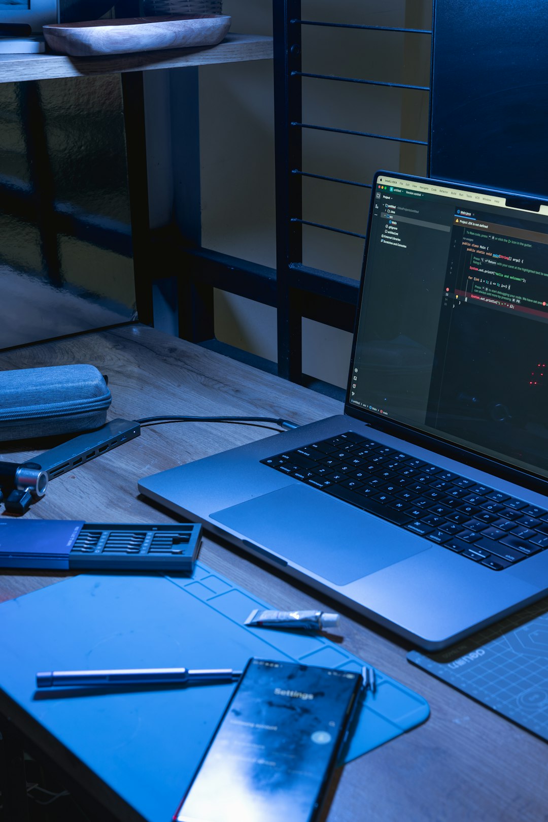 laptop and phone on a desk with coding software open cryptography books encryption keys developer desk