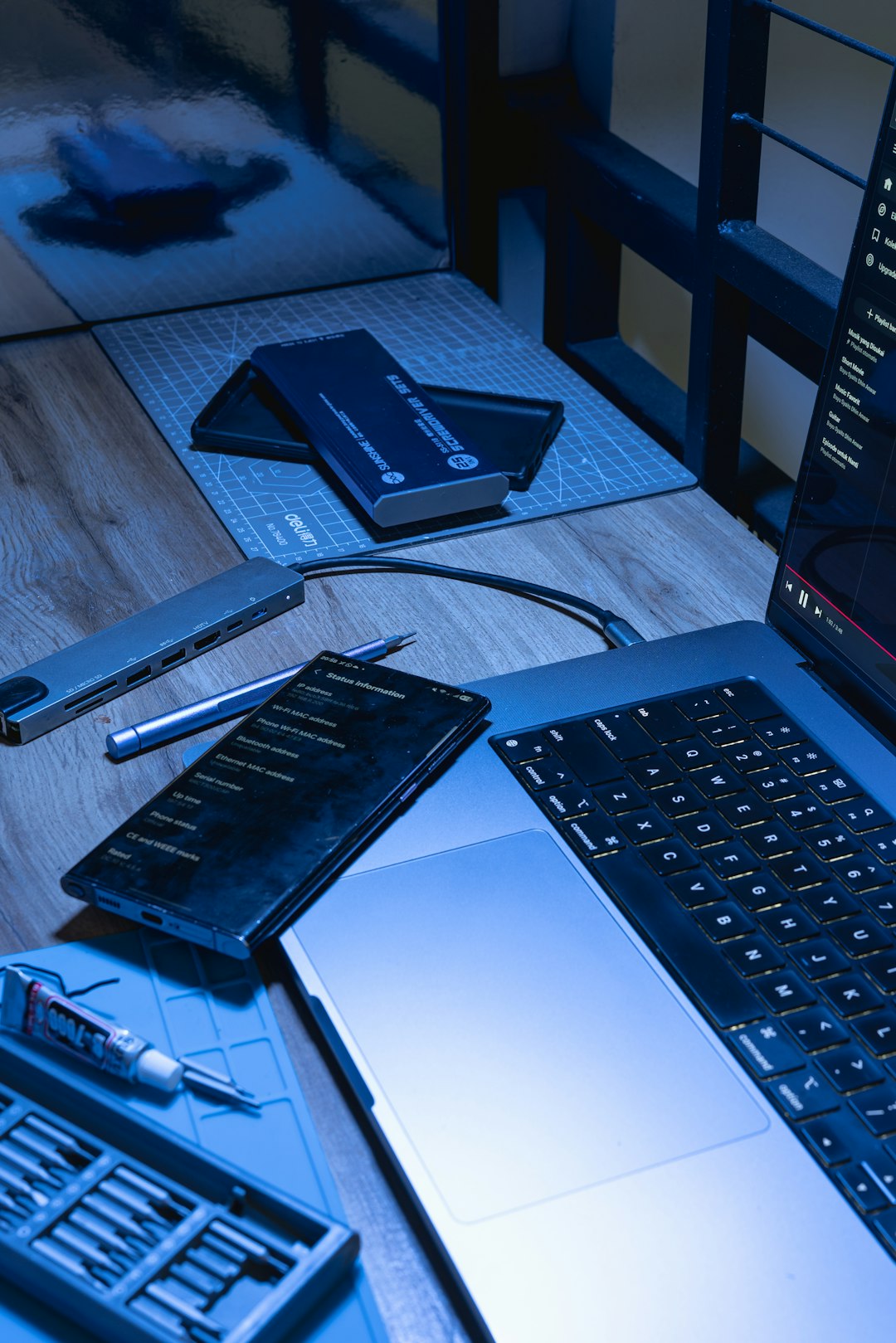 laptop smartphone and repair tools on a desk cryptography books encryption keys developer desk