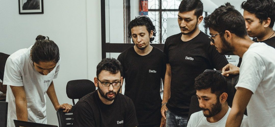 people near a black top computer in a room startup workflow prototype handoff product team
