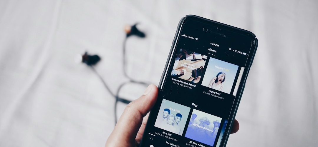 person holding iphone 6 turned on music search browser interface album library streaming service