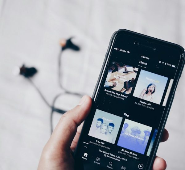 Spotify Downloader to MP3: Best Legal Alternatives Compared 8 person holding iphone 6 turned on music search browser interface album library streaming service