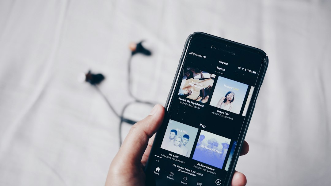 person holding iphone 6 turned on music search browser interface album library streaming service