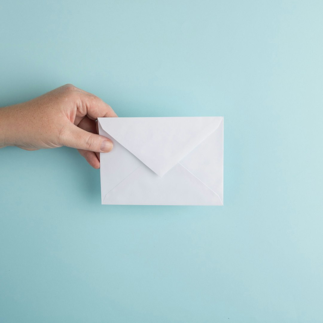 person showing white envelope mail notice employment card immigration paperwork