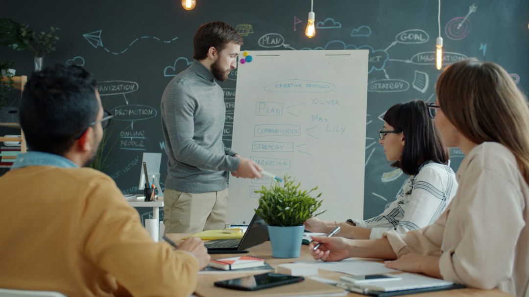 team collaborating around a whiteboard in a modern office public relations team media database campaign planning