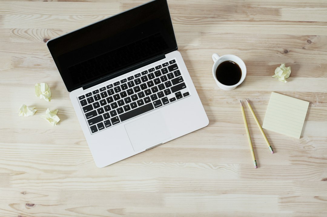 turned off macbook pro beside white ceramic mug filled with coffee business owner laptop compliance form coffee