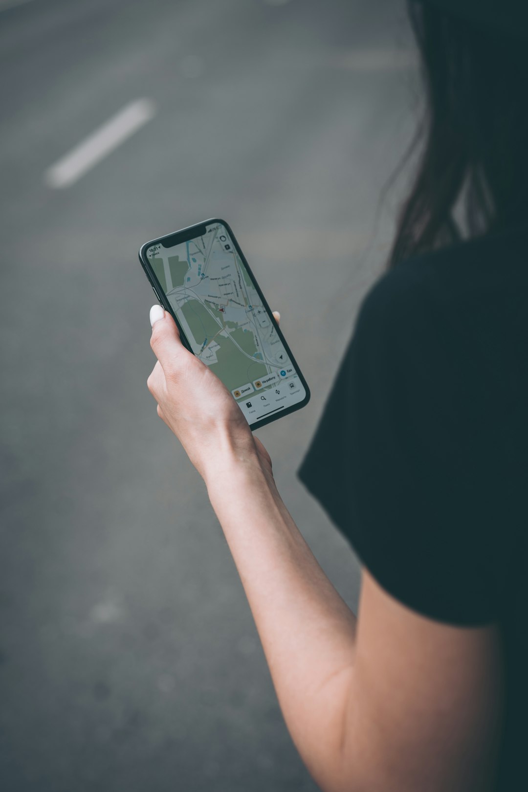 woman in black shirt holding black smartphone mobile network map coverage