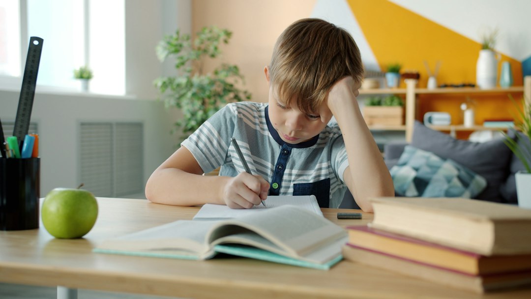 young boy concentrating while doing homework at desk ipad notes apple pencil student desk study apps